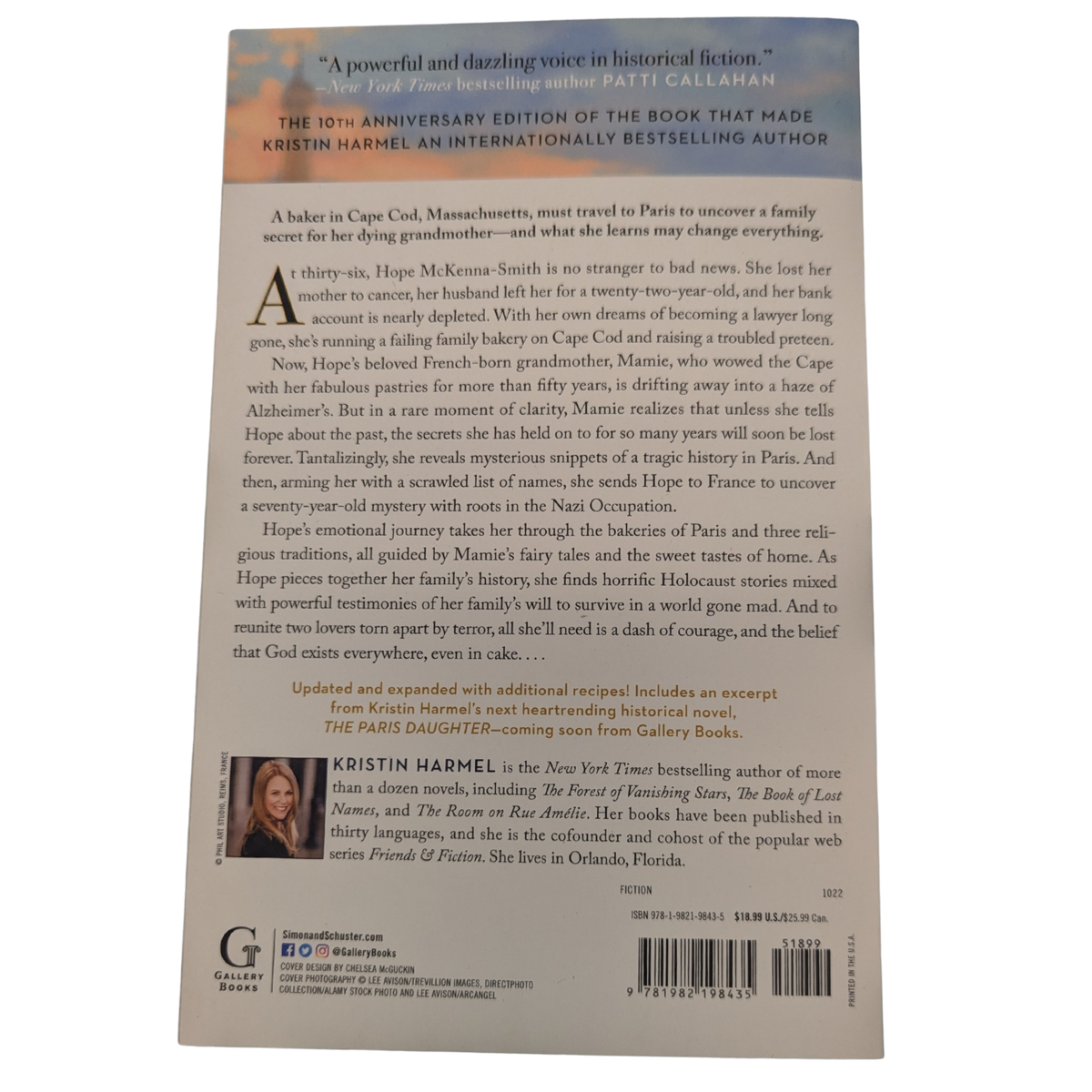 The Sweetness of Forgetting by Kristin Harmel Updated 10th Anniversary Edition paperback book cover featuring a woman in a turquoise coat walking toward the Eiffel Tower in Paris