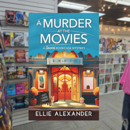 A Murder at the Movies by Ellie Alexander cozy mystery paperback cover featuring a vintage movie theater with glowing lights, a red carpet entrance, movie posters, and a popcorn container.