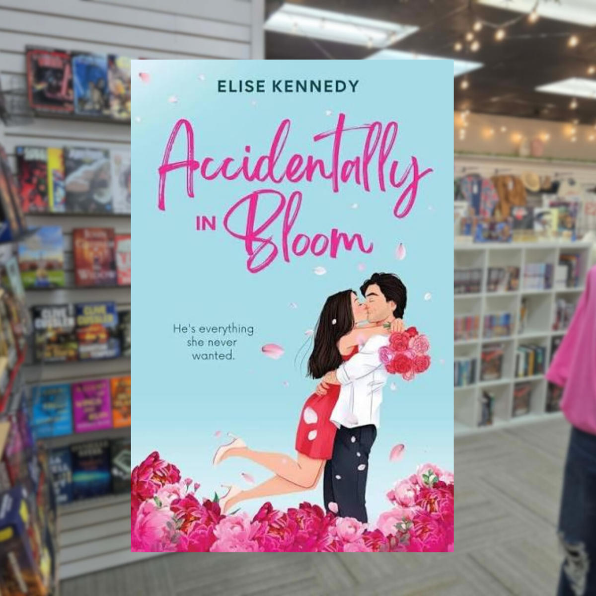 Accidentally in Bloom by Elise Kennedy paperback romance book featuring a couple kissing surrounded by pink flowers.