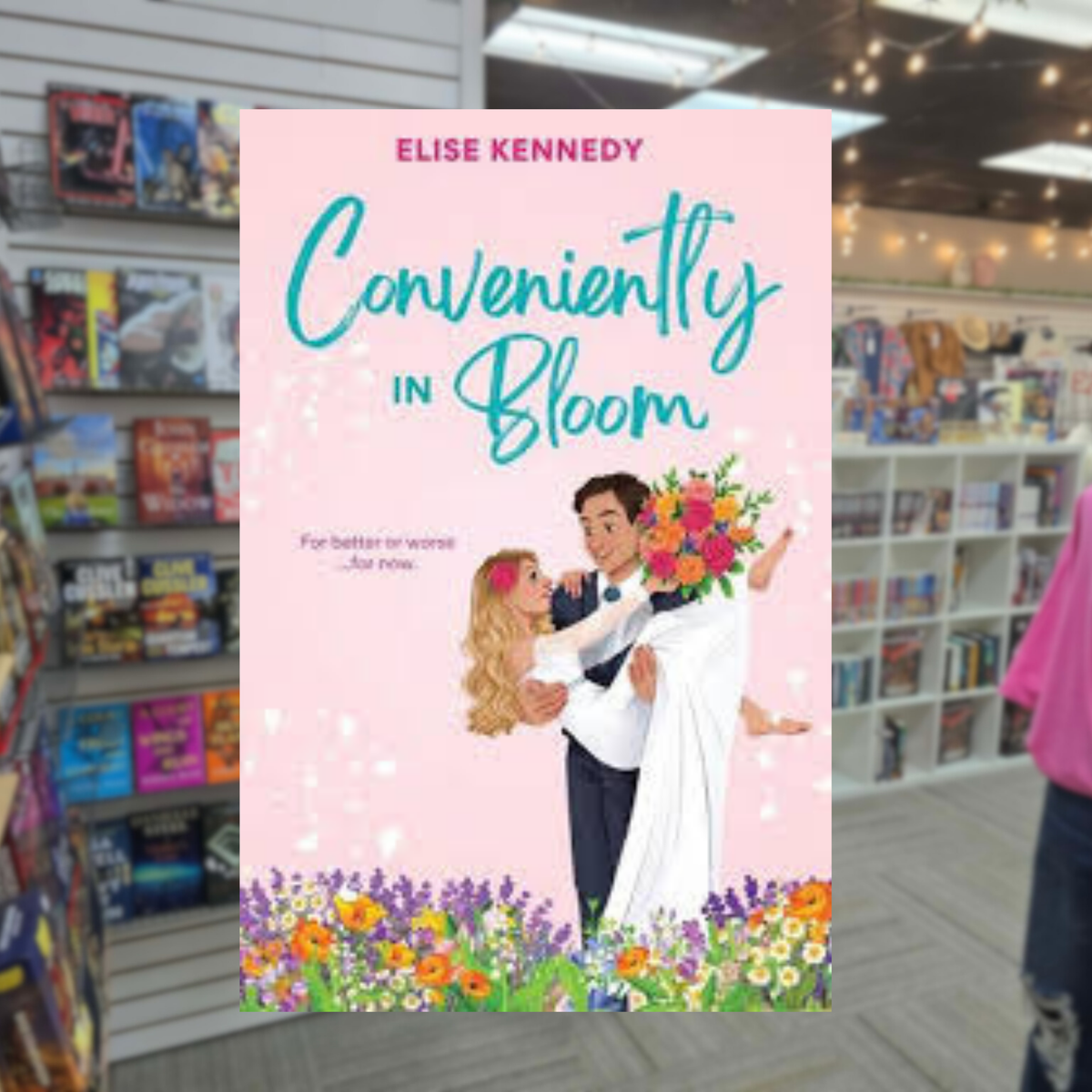 Conveniently in Bloom by Elise Kennedy romance book cover featuring an illustrated bride and groom holding colorful flowers against a pink background with blooming flowers.