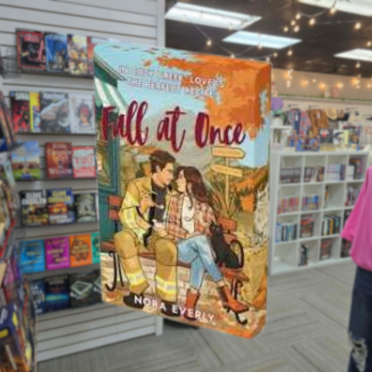 Fall at Once by Nora Everly illustrated autumn romance book cover featuring a couple surrounded by colorful fall scenery