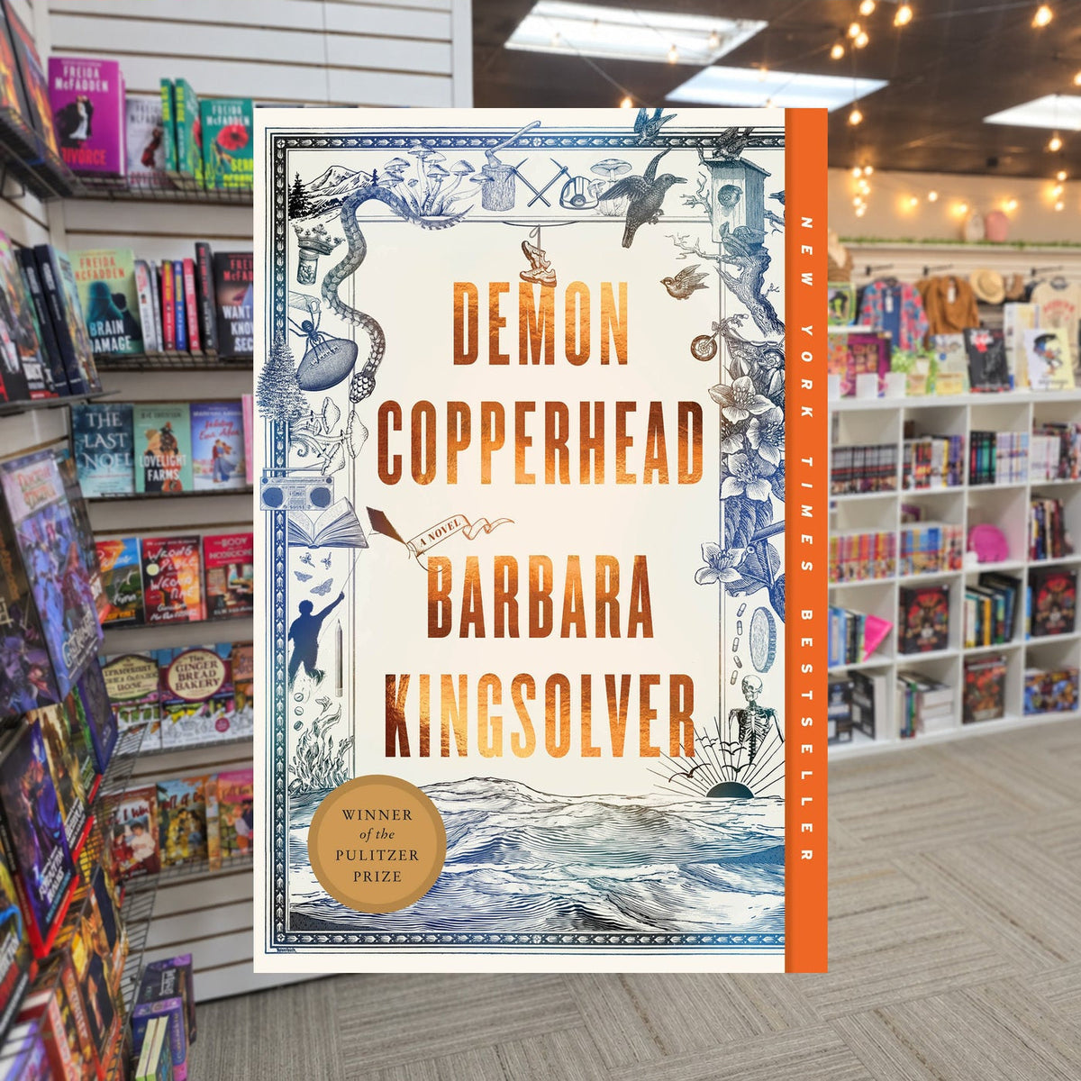 Demon Copperhead by Barbara Kingsolver — actual cover on The Perk bookstore background