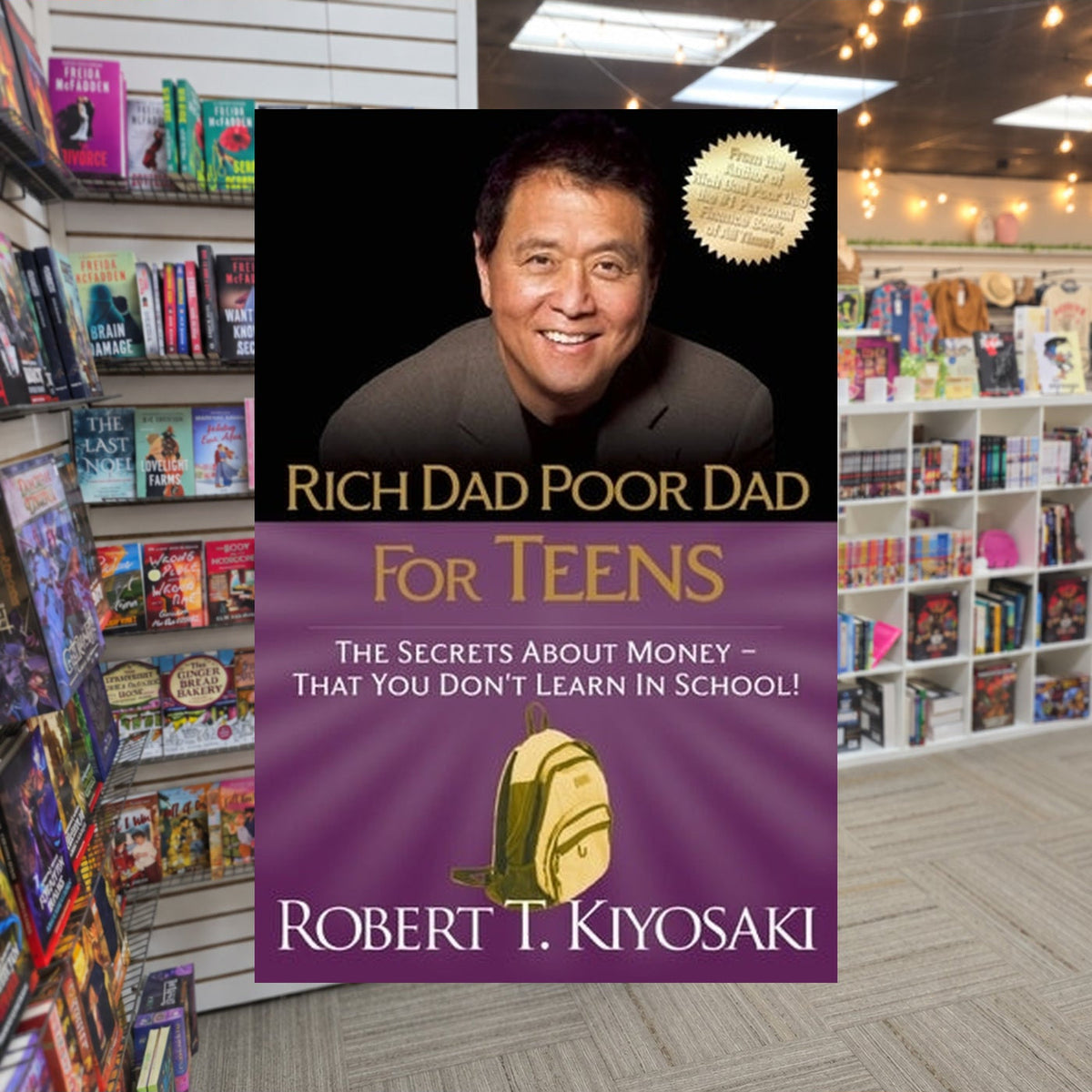 Rich Dad Poor Dad for Teens: The Secrets about Money--That You Don't Learn in School! by Robert T. Kiyosaki — actual cover on The Perk bookstore background