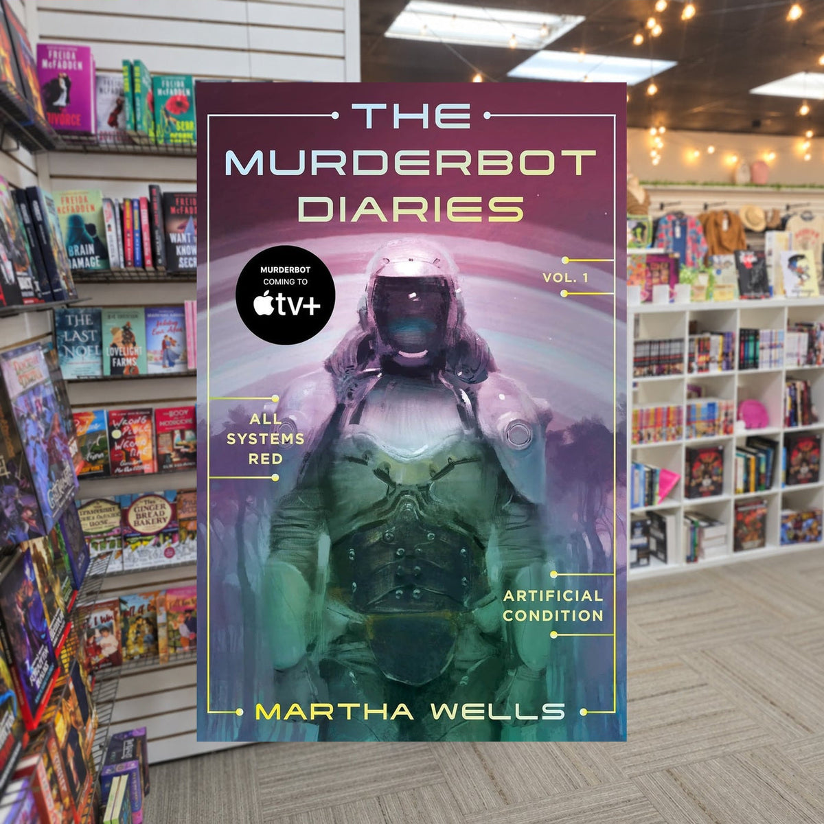 The Murderbot Diaries — actual cover on The Perk bookstore background
