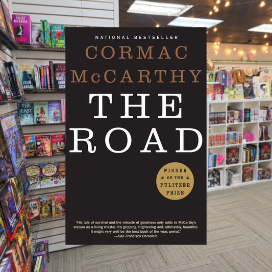 The Road by Cormac McCarthy — actual cover on The Perk bookstore background