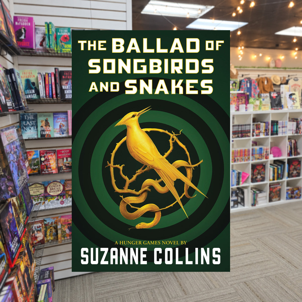 The Hunger Games #4 The Ballad of Songbirds and Snakes by Suzanne Collins — actual cover on The Perk bookstore background
