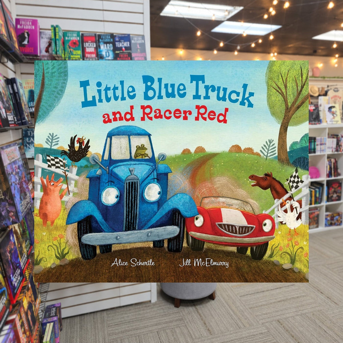 Little Blue Truck and Racer Red by Alice Schertle ,  Jill McElmurry — actual cover on The Perk bookstore background