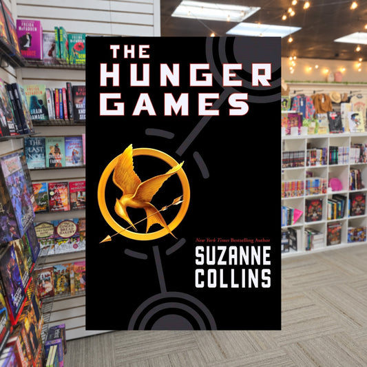 The Hunger Games #1: The Hunger Games by Suzanne Collins — actual cover on The Perk bookstore background