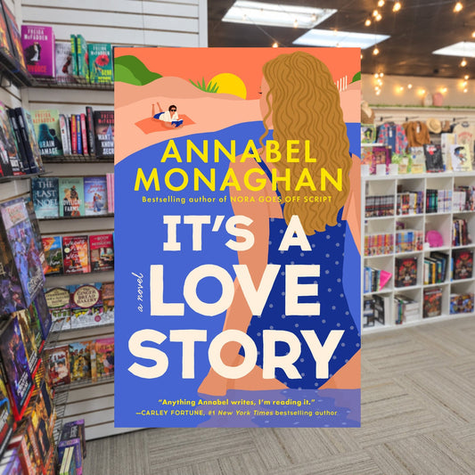 It's a Love Story by Annabel Monaghan — actual cover on The Perk bookstore background
