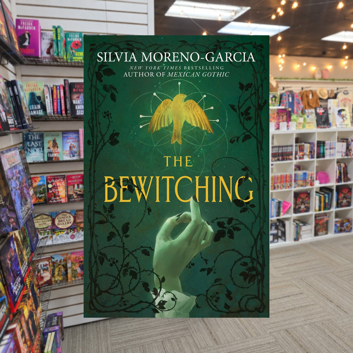 The Bewitching by Silvia Moreno-Garcia — actual cover on The Perk bookstore background
