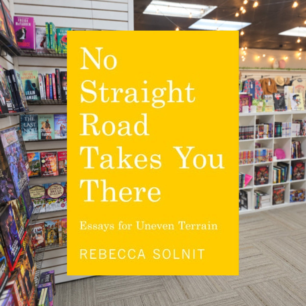 No Straight Road Takes You There by Rebecca Solnit — actual cover on The Perk bookstore background