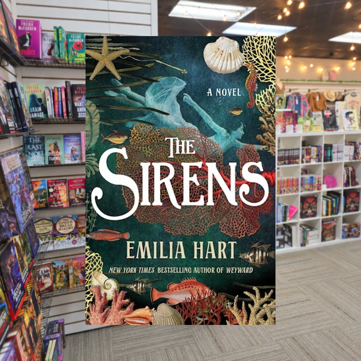 The Sirens by Emilia Hart — actual cover on The Perk bookstore background