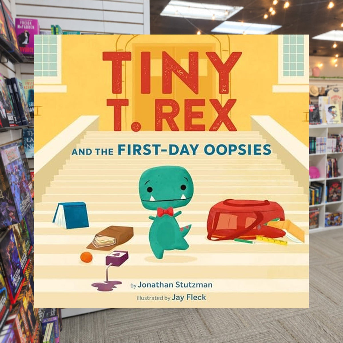 Tiny T. Rex and the First-Day Oopsies: A Back-to-School Book by Jonathan Stutzman — actual cover on The Perk bookstore background