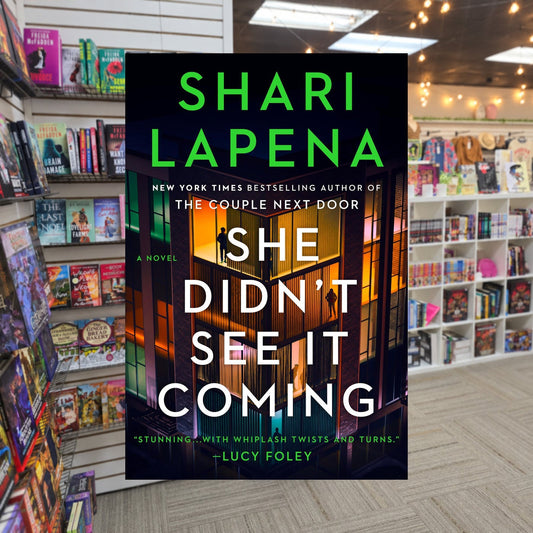 She Didn't See It Coming by Shari Lapena — actual cover on The Perk bookstore background