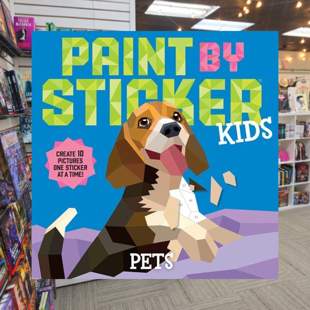 Paint by Sticker Kids: Pets: Create 10 Pictures One Sticker at a Time! by Workman Publishing — actual cover on The Perk bookstore background