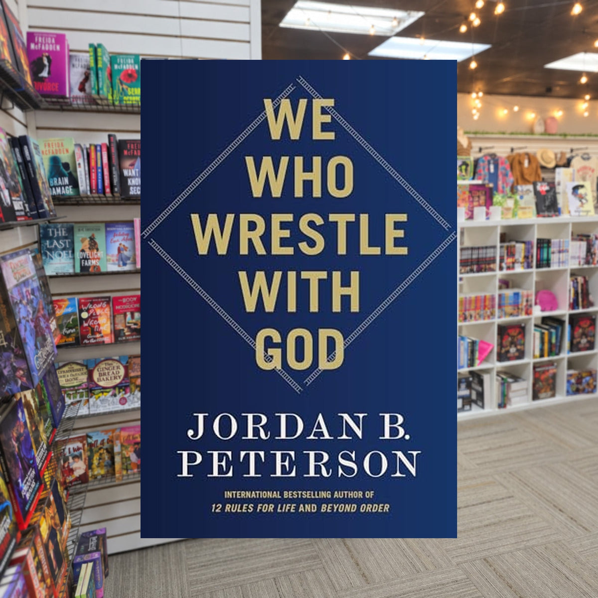 We Who Wrestle with God: Perceptions of the Divine by Jordan B. Peterson — actual cover on The Perk bookstore background