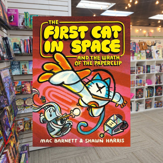 The First Cat in Space and the Wrath of the Paperclip by Mac Barnett , — actual cover on The Perk bookstore background