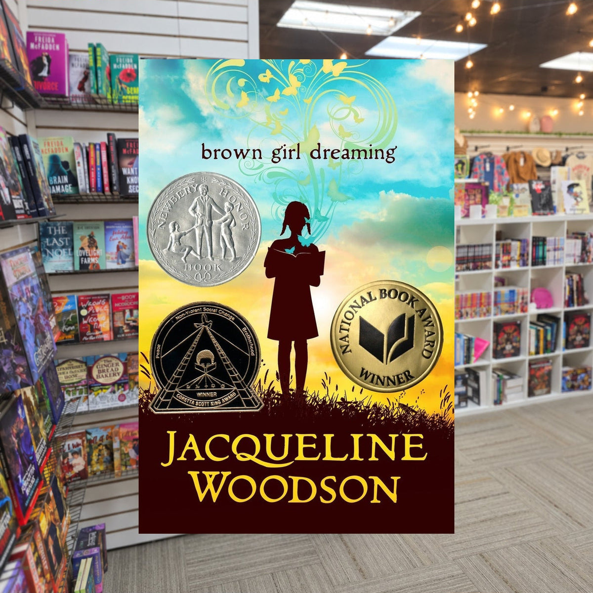 Brown Girl Dreaming by Jacqueline Woodson — actual cover on The Perk bookstore background