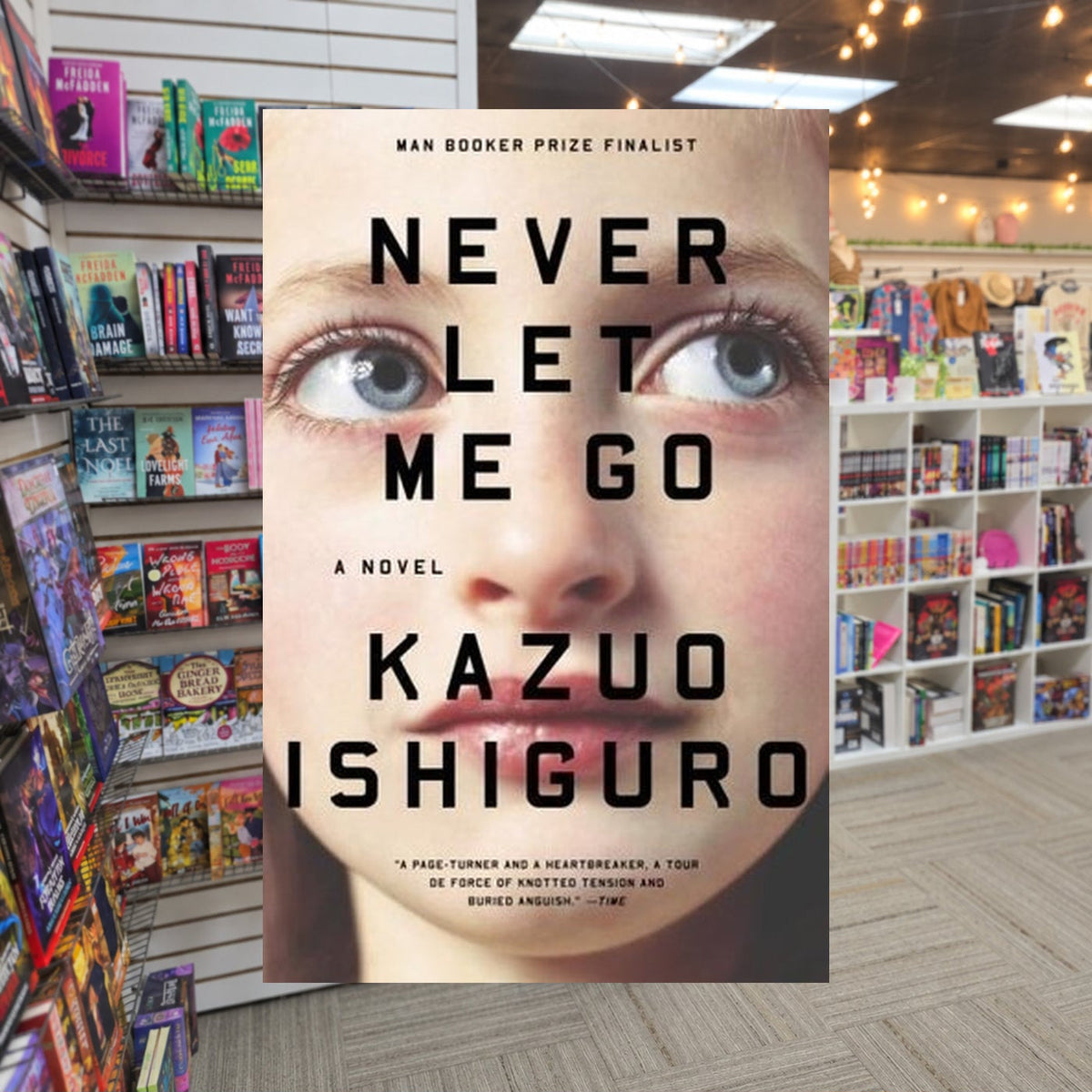 Never Let Me Go by Kazuo Ishiguro — actual cover on The Perk bookstore background