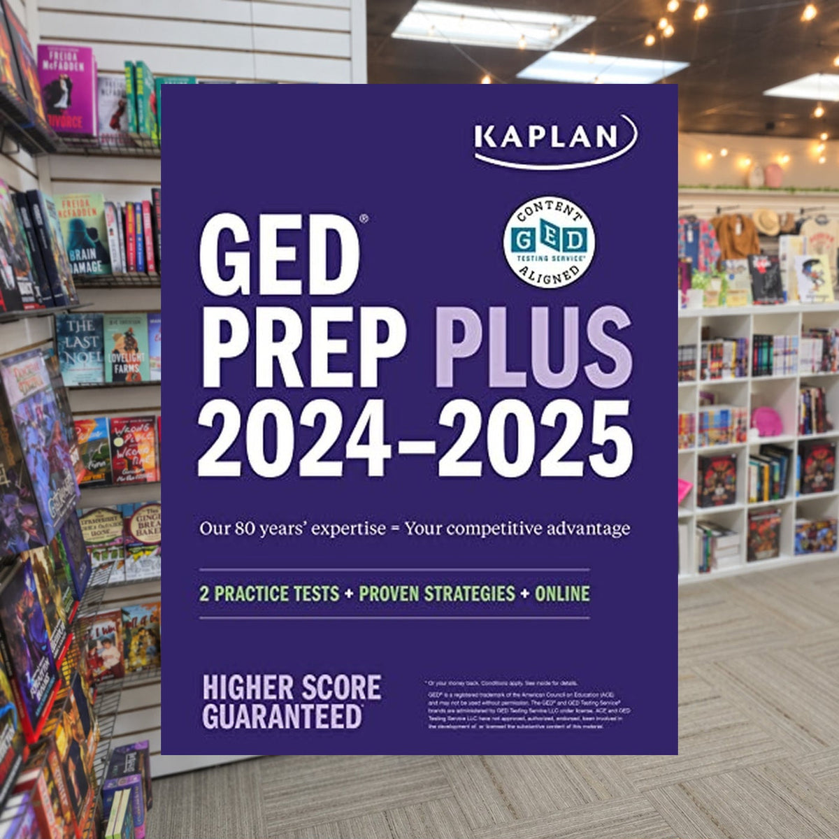 GED Test Prep Plus 2024-2025 by Caren Van Slyke — actual cover on The Perk bookstore background