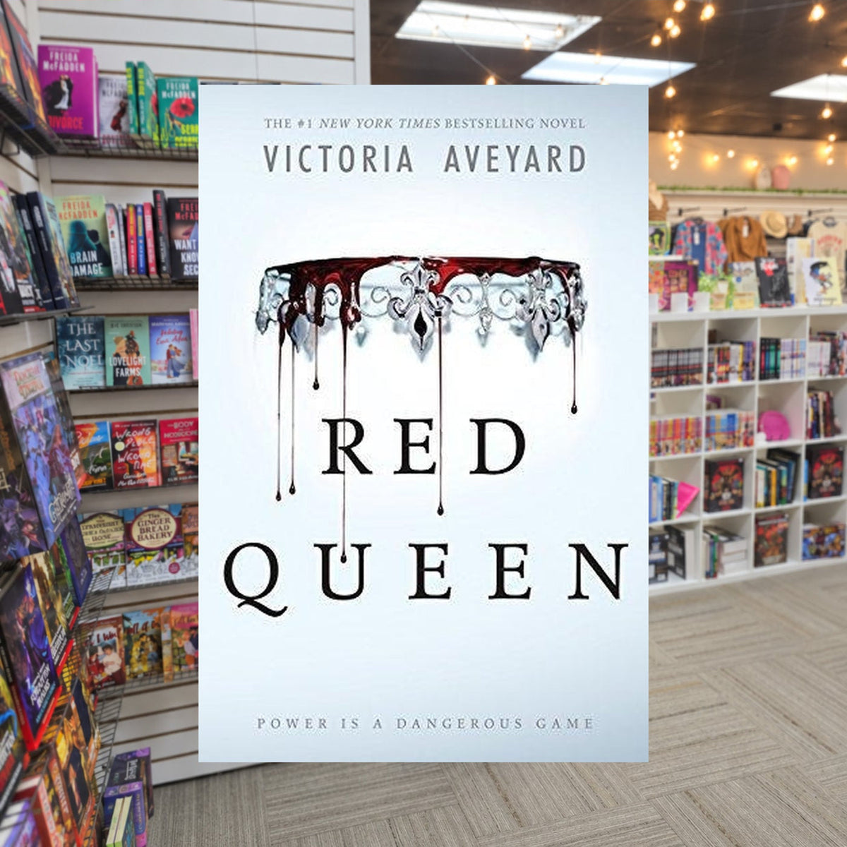 Red Queen by Victoria Aveyard — actual cover on The Perk bookstore background