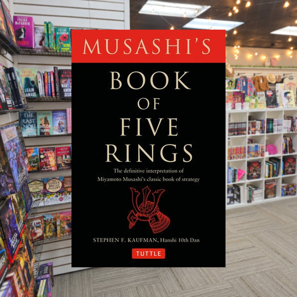 Musashi's Book of Five Rings: The Definitive Interpretation of Miyamoto Musashi's Classic Book of Strategy by Miyamoto Musashi and Stephen F. Kaufman — actual cover on The Perk bookstore background