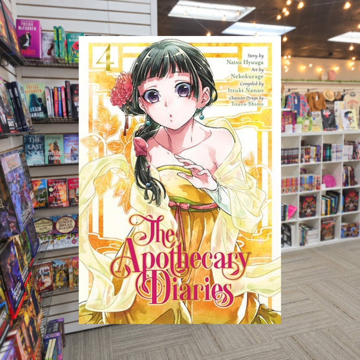 The Apothecary Diaries, Vol. 4 by Nekokurage and Natsu Hyuuga — actual cover on The Perk bookstore background