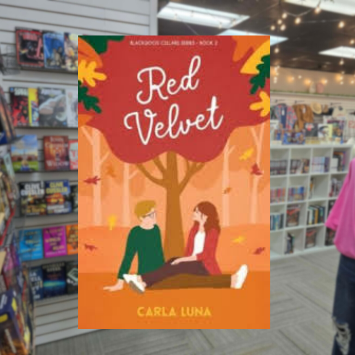 Red Velvet by Carla Luna romance book cover featuring an illustrated couple sitting together beneath a large red autumn tree, surrounded by orange and yellow fall foliage.