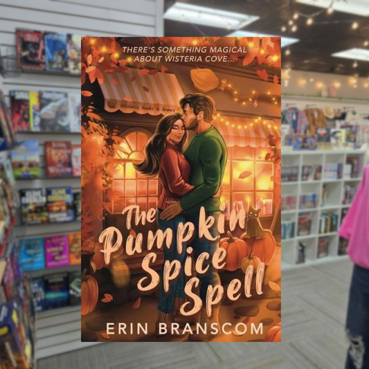 The Pumpkin Spice Spell by Erin Branscom romance book cover featuring an illustrated couple embracing outside a glowing Wisteria Cove bookshop and brewery, surrounded by pumpkins, autumn leaves, and warm string lights.