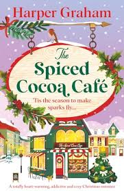 The Spiced Cocoa Café by Harper Graham Christmas romance book cover featuring a charming festive café, snow-covered buildings, Christmas greenery, colorful holiday decorations, and a snowy winter village.