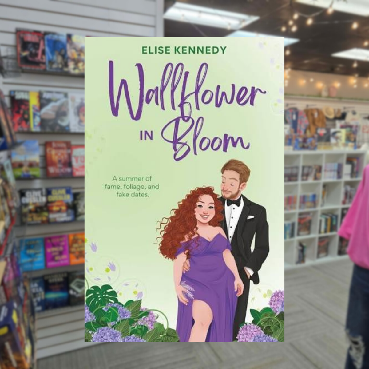 Wallflower in Bloom by Elise Kennedy spicy contemporary romance paperback cover featuring an illustrated red-haired woman in a purple dress embracing a handsome man in a black tuxedo, surrounded by colorful flowers against a pale green background.